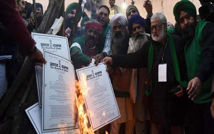 Farmers burn the copies of the three farm laws on the occasion of Lohri on Wednesday (Image credit: New Indian Express)