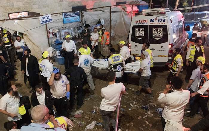 Security officials and rescuers carry a body after the tragedy at Mount Meron in Israel (Image credit: USA Today)