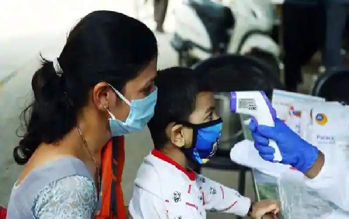 File photo of a medic checking the temperature of a child (Image credit: Mint)