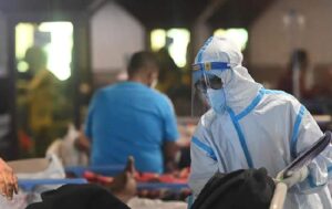 A doctor in PPE Kit attending a COVID-19 patient (Image credit: NDTV.com)